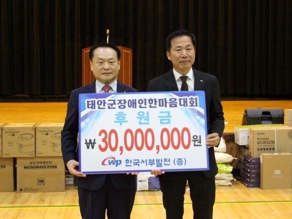 한국서부발전은 지난 24일 충남 태안 군민체육관에서 열린 ‘제29회 태안군 장애인 한마음 대회’에 참여했다. 강세훈 서부발전 기획본부장(오른쪽)과 이종만 태안지체장애인협회장이 후원금 전달 기념 촬영을 했다. 사진=서부발전