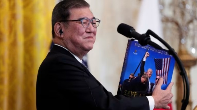 이시바 시게루 일본 총리가 2월 7일 백악관에서 열린 공동 기자회견에서 도널드 트럼프 미국 대통령의 선물을 들고 있다. 사진=로이터