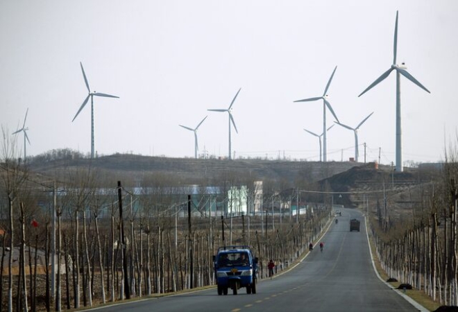 지난 2009년 11월 28일(현지시각) 중국 랴오닝성 둥강 지역의 한 풍력발전소 인근을 차량이 지나가고 있다. 사진=로이터