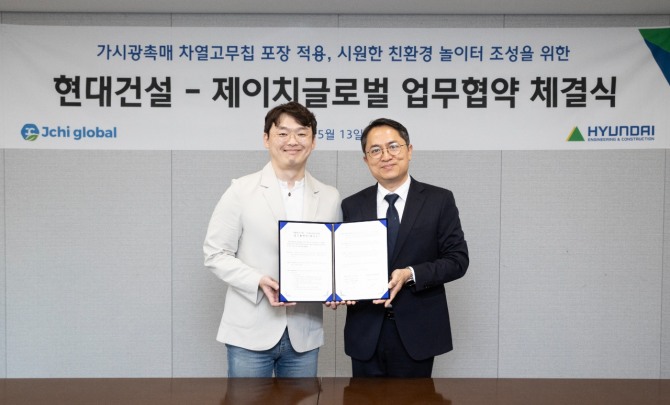 지난 13일 최광호 현대건설 건축주택설계실장(사진 오른쪽)과 오주명 제이치글로벌 대표(사진 왼쪽)가 서울 종로구 계동에 위치한 현대건설 본사에서‘가시광촉매 차열 고무칩 포장기술 적용을 위한 업무협약’을 체결하고 기념 촬영을 하고 있다. 사진=현대건설