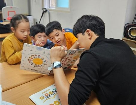 현대해상이 다문화 아동의 학습능력 향상과 정서발달을 위해 운영하는 '마음한글'의 대학생 멘토가 다문화 아동들에게 동화책 한글 수업을 진행하고 있다. 사진=현대해상