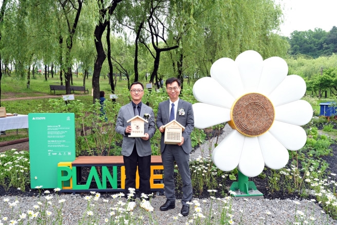 지난 20일 엄홍석 현대엔지니어링 커뮤니케이션실장(사진 왼쪽)과 이수연 서울시 정원도시국장(사진 오른쪽)이 '세계 벌의 날'을 맞아 서울 강북구 북서울꿈의숲에서 진행된 '꿀벌 서식지' 개장식 행사 이후 포토존에서 기념 촬영을 하고 있다. 사진=현대엔지니어링