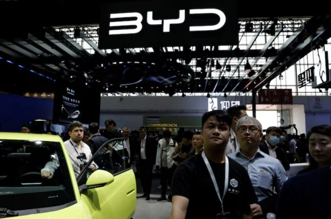 2024 베이징 국제 모터쇼. 2024년 4월 25일 중국 베이징에서 열린 베이징 국제 모터쇼(오토 차이나 2024)에서 관람객들이 비야디(BYD) 로고 옆을 지나가고 있다. 사진=로이터