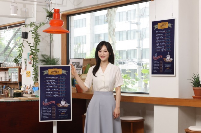 삼성전자 모델이 디지털 종이에 잉크 기술을 적용한 초저전력 디스플레이 '삼성 컬러 이페이퍼'와 포즈를 취하고 있다. 사진=삼성전자
