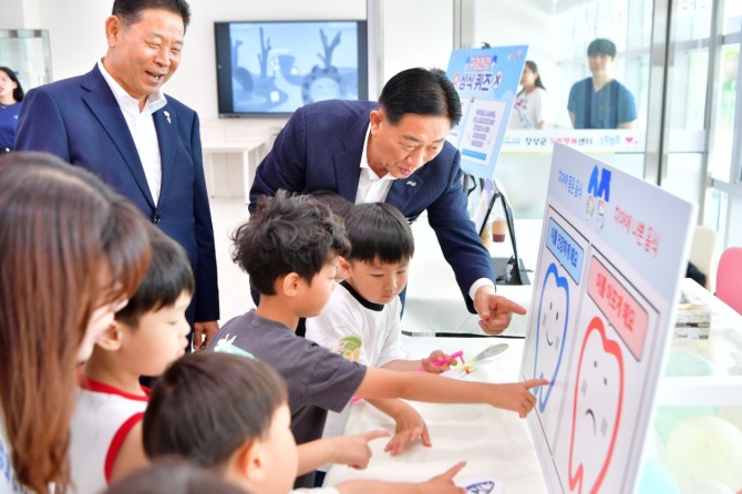 지난 9일 김한종 장성군수(가운데)와 심민섭 장성군의회 의장 구강건강 체험존에서 아이들과 함께하고 있는 모습. 사진=전남 장성군