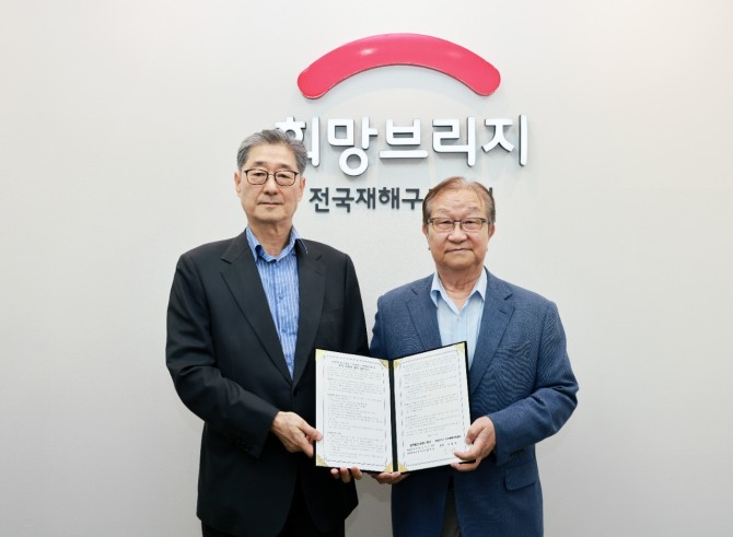 희망브리지 송필호 회장(왼쪽)과 법무법인 동인 정충수 명예대표변호사가 서울 마포구 희망브리지에서 협약 체결 후 기념사진을 찍고 있다.  /사진=희망브리지