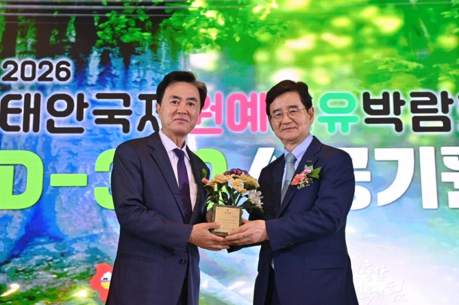 김선규 호반그룹 회장(오른쪽)이 17일 충남 태안군 안면도 아일랜드 리솜에서 열린 2026 태안국제원예치유박람회 D-300 성공 기원행사에서 김태흠 충남도지사로부터 민간위원장 위촉패를 받고 기념촬영을 하고 있다. 사진=호반그룹
