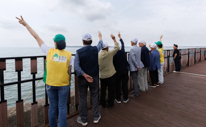 지난 17일 충남 행담도 바닷가에서 참전유공자들과 신천지자원봉사단 봉사자들이 산책 후 기념 촬영을 하고 있다. 사진=신천지자원봉사단 화성·오산지부