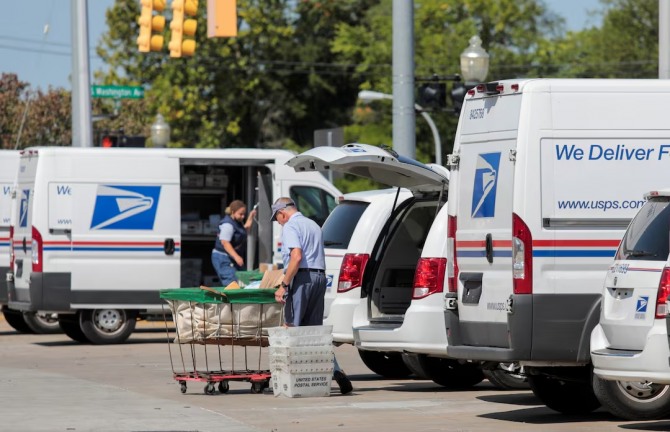 미국 미시간주 로열 오크에 있는 우체국 밖에서 USPS(United States Postal Service) 근로자들이 우편물을 배달 트럭에 싣고 있다. 사진=로이터