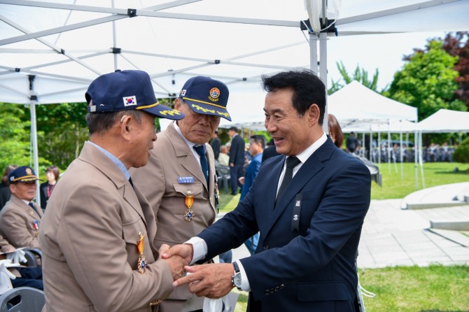 지난 6월 6일 현충일 추념식에서 백영현 포천시장이 국가 유공자들과 인사하고 있다. 사진=포천시