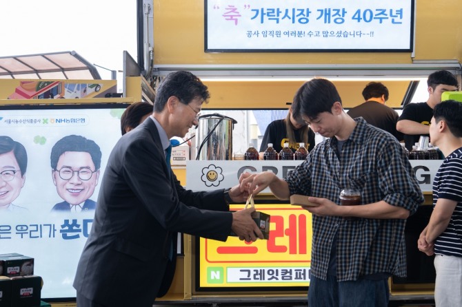 강태영 NH농협은행장이 가락시장 40주년 기념행사에서 쌀 소비 촉진 홍보활동의 일환으로 농협 즉석밥을 나눠 주고 있다. 사진=농협은행