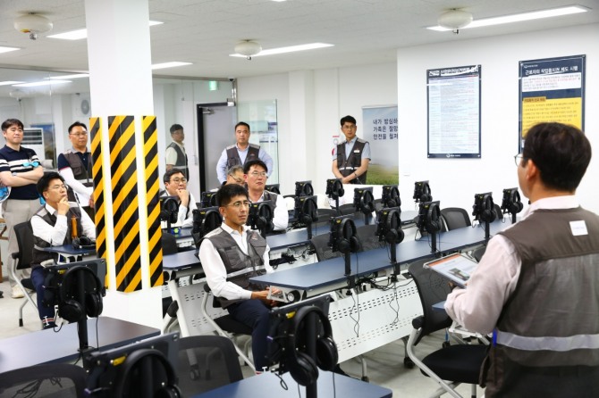 한화 건설부문은 서울역북부역세권 복합개발사업 공사 현장에 안전교육과 체험교육, 통합관제 등을 한곳에서 실시하는 건설안전보건센터를 구축했다고 26일 밝혔다. 사진은 김승모 한화 건설부문 대표(오른쪽 네번째)가 안전교육장에서 태블릿PC 사용법을 듣고 있는 모습. 사진=한화 건설부문