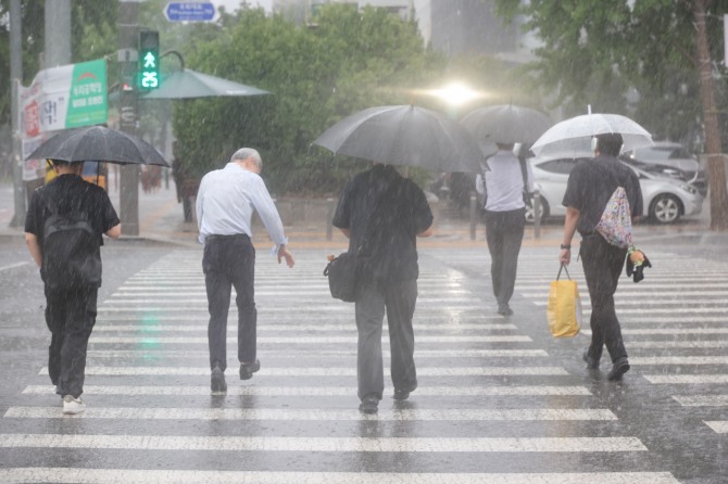 서울 서남권에 호우주의보가 발효된 8일 서울 영등포구 여의도 국회 인근에서 시민들이 우산을 쓰고 이동하고 있다. 사진=연합뉴스