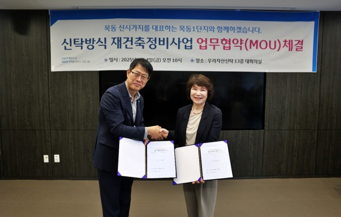 김범석 우리자산신탁 대표(왼쪽)와 정현숙 목동1단지 재건축준비위원장(오른쪽)이 재건축 협력을 다짐하며 악수를 하고있다 사진=우리금융그룹