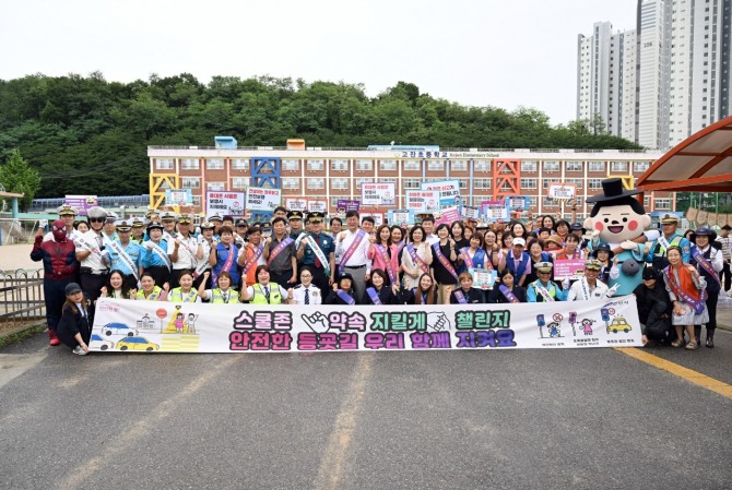 이민근 안산시장(두번 째 줄 가운데)이 지난 15일 고잔초등학교에서 진행된 교통안전 합동 캠페인 참여자들과 함께 기념촬영을 하고 있다. 사진=안산시