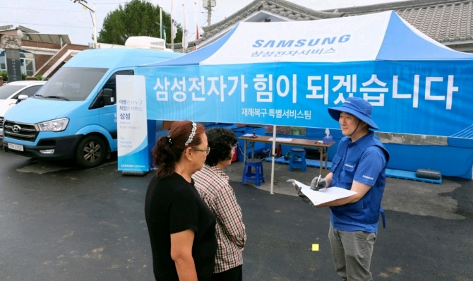 삼성전자서비스 엔지니어가 18일 충청남도 예산군 삽교읍에서 주민 수해 복구 특별 점검 서비스를 실시하고 있다. 사진=삼성전자서비스