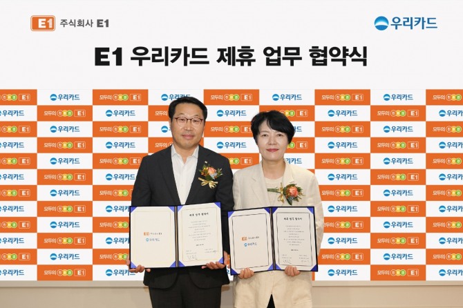 지난달 25일 용산구 한강대로 LS용산타워에 위치한 E1 본사에서 박명신 우리카드 개인영업본부장(오른쪽)과 김수근 E1 영업본부장이 업무제휴를 체결하고 기념사진을 촬영하고 있다. 사진=우리카드 제공.
