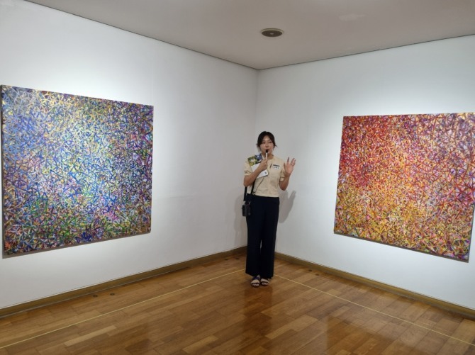 성희승 작가가 경기도 광주 영은미술관 제2전시장에서 개인전 ‘별을 새기다 Engraving the Stars’을 지난 19일 오픈해 관객을 맞이하고 있다. 성 작가가 작품을 설명하고 있다. 사진=성희승 작가 제공