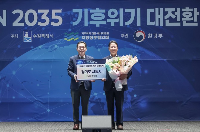 지난 24일 수원컨벤션센터에서 열린 '기후위기 대전환 포럼 본행사에서 시흥시가 환경부장관상을 받아 양순필 시흥시 환경국장(오른쪽)이 지방정부협의회 회장도시인 이재준 수원시장(왼쪽)과 기념촬영을 하고 있다. 사진=시흥시