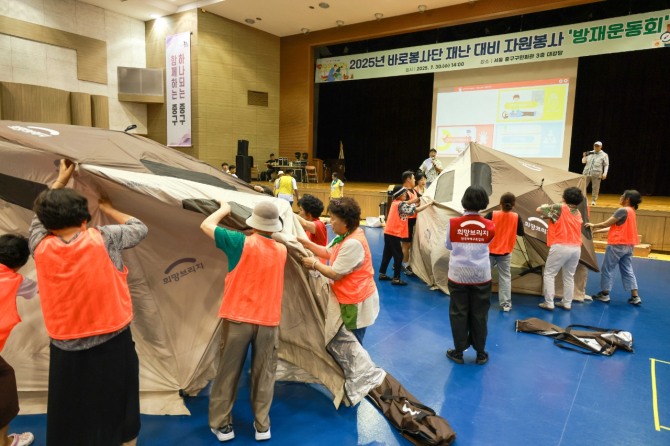 지난 30일 서울 중구 구민회관에서 열린 2025년 바로봉사단 재난 대비 자원봉사 방재운동회에서 참가자들이 희망브리지의 이재민 대피소 쉘터를 설치하고 있다.  /사진=희망브리지
