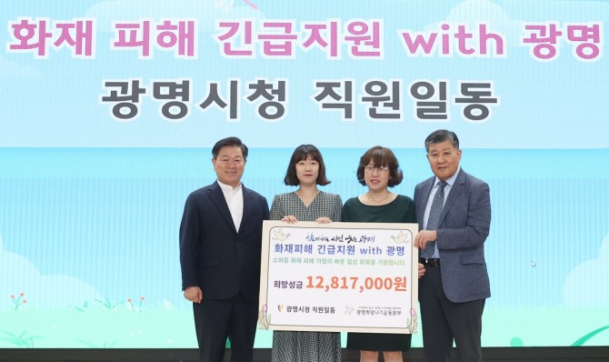 박승원 광명시장(왼쪽 첫 번째)과 총무과 직원들이 7일 오전 시청 대회의실에서 열린 소하동 화재 피해 복구 성금 전달식에서 공무원 886명이 모은 성금을 광명시사회복지협의회 광명희망나기운동본부에 전달하고 기념사진을 촬영하고 있다. 사진=광명시