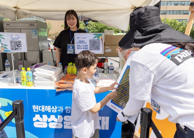 현대해상 관계자가 8일 서울 광화문 광장에서 열린 ‘여름 상상 놀이터’에서 어린이 참여자의 스탬프 챌린지를 돕고 있다. 사진=현대해상