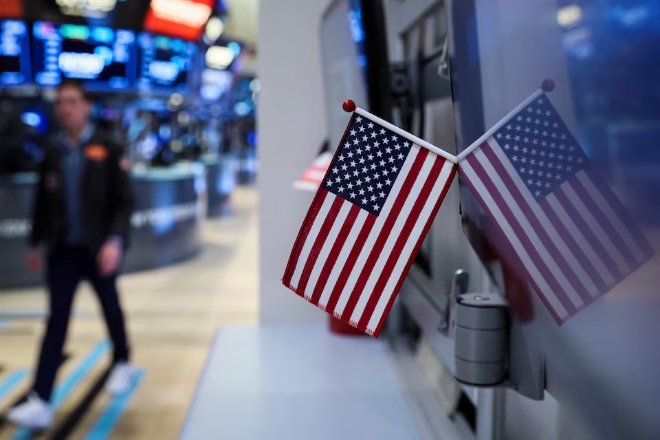 지난 2022년 3월 21일(현지시각) 미국 뉴욕증권거래소(NYSE)에서 한 트레이더가 성조기가 걸린 가운데 업무를 보고 있다. 사진=로이터