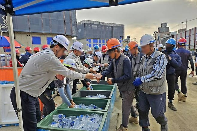 KCC건설이 지난 22일 전국 모든 현장에서 ‘중대재해 제로를 위한 안전한 일터 조성 캠페인’ 선포식을 개최했다. KCC건설 직원들이 공사현장에서 근로자들에게 음료수를 나눠주는 모습. 사진=KCC건설