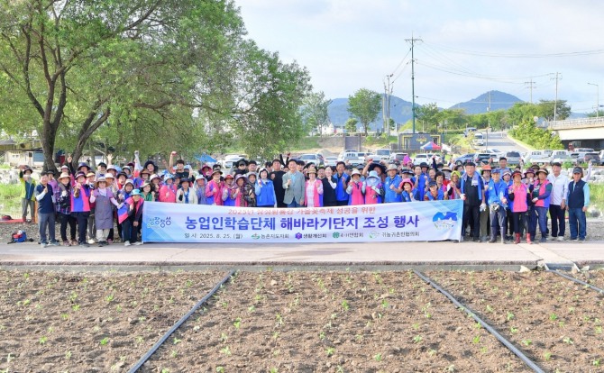 지난 25일 황룡강에서 올해 장성군 가을꽃축제 준비의 일환으로 해바라기 식재 행사를 갖고 기념촬영을 하고 있다.  사진=전남 장성군