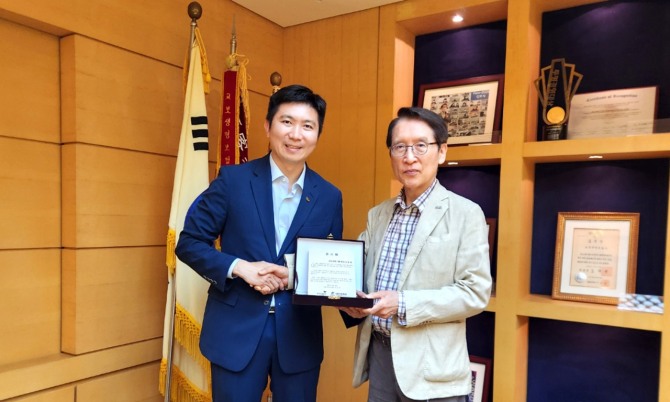 창재 교보생명 대표이사 겸 이사회 의장(오른쪽)과 유승민 대한체육회장이 지난 25일 서울 광화문 교보생명 본사에서 감사패 전달식을 마친 뒤 기념촬영을 하고 있다. 사진=교보생명 제공