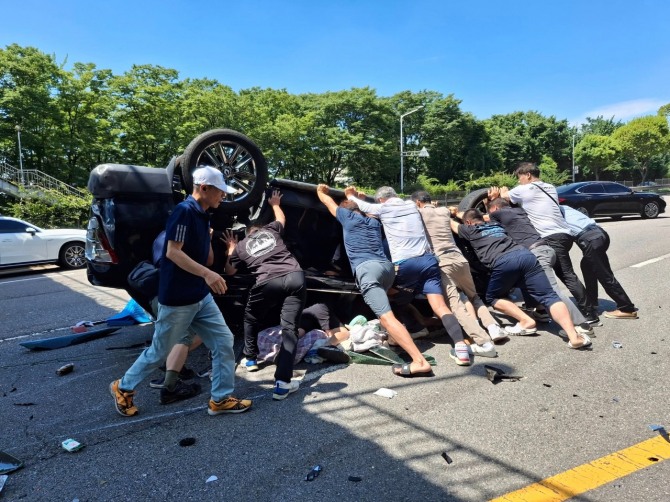 지난달 2일 상록구 부곡동 육교 인근에서 발생한 차량 전복사고 현장에서 시민들이 탑승자를 구하고 있다. 사진=안산시