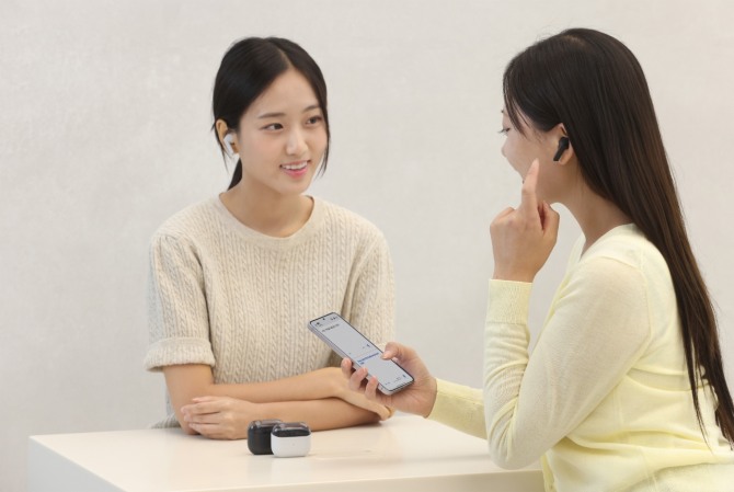 삼성전자 모델이 19일 국내 출시하는 '갤럭시 버즈3 FE'의 '실시간 통역' 기능과 '액티브 노이즈 캔슬링' 기능을 체험하고 있다. 사진=삼성전자
