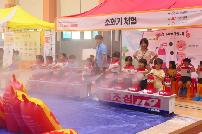 강원지역 학교 교내 강당에서 최근 열린 안전교육 체험 활동인 '세이프 히어로즈'에 참여한 어린이와 아동들이 소화기를 분사하며 안전 체험을 하고 있다. 사진=새마을금고 