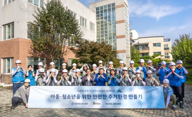 봉사활동에 참여한 대한항공-아시아나항공 양사 임직원 20여 명이 노후화된 벽지 교체 등을 지원하고 기념사진을 촬영하고 있다. 사진=대한항공