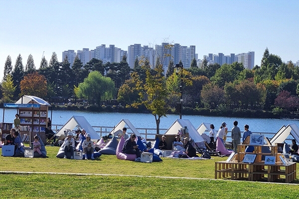 호숫가 잔디밭 야외도서관에서 책을 읽는 시민들(2024 독서대전). 사진=고양시