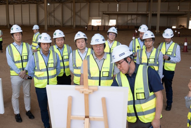 정의선 회장(둘째 줄 가운데), 호세 무뇨스 사장(왼쪽에서 두 번째)이 박원균 HMMME 법인장(맨 앞)에게서 신공장에 대한 보고를 받고 있다. 사진=현대차그룹