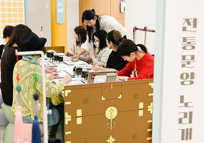김포공항 국제선 터미널에서 진행된 전통문화 체험행사에서 공항 이용객이 노리개 만들기 체험에 참여하고 있다. 사진=한국공항공사