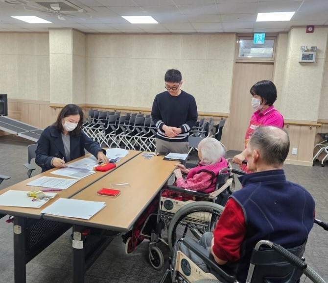 지난 30일 민생회복 소비쿠폰 TF팀이 시립노인요양센터를 방문해 입소 어르신을 대상으로 민생회복 소비쿠폰 신청을 지원하고 있다. 사진=광명시
