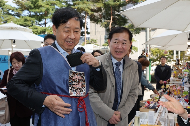 구윤철 부총리 겸 기획재정부 장관이 12일 서울 중구 두타몰 광장에서 열린 '코리아 그랜드 페스티벌'을 현장 점검하는 도중 상품 구매를 위해 지갑을 꺼내고 있다. 사진=연합뉴스 