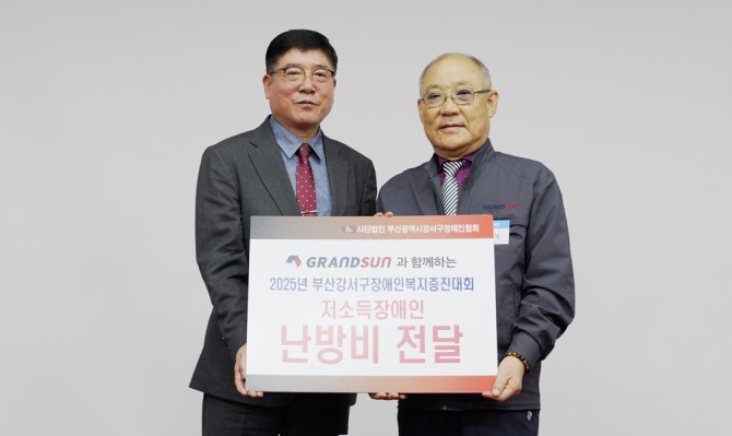 황관복 그랜드썬기술단 전무(사진 우측)가 강서구장애인협회에 저소득장애인을 위한 난방비를 전달하고 있다. 사진=그랜드썬기술단