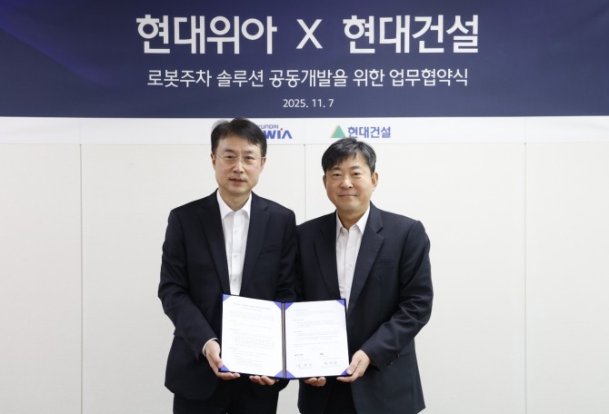 백익진 현대위아 모빌리티솔루션사업부 상무(왼쪽)와 김재영 현대건설 기술연구원 원장이 7일 경기도 의왕시 현대위아 의왕연구소에서 열린 ‘로봇 친화형 주차솔루션 공동개발을 위한 업무협약식’에서 기념 사진을 찍고 있다. 사진=현대위아