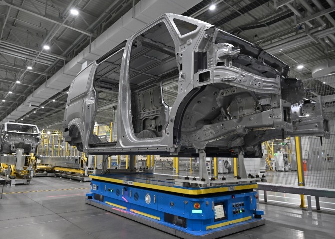 무인운반차량(AGV)이 PV5 차체를 운반하는 모습. 사진=기아