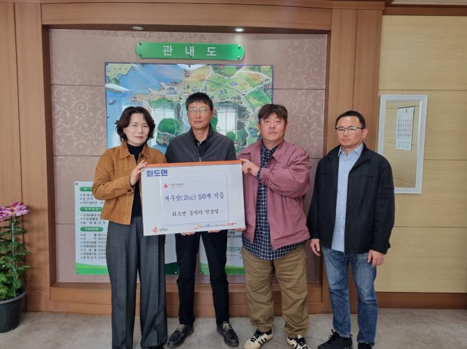 지난 14일 강화군 화도면 동막리 주민 민경섭(왼쪽 두 번째)씨가  화도면 어려운 이웃들에게 새우젓을 기탁하고 있다.  사진=강화군 