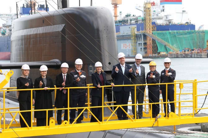 24일 멜라니 졸리 캐나다 산업부 장관(가운데)이 김희철 한화오션 대표이사(왼쪽에서 네 번째), 강환석 방위사업청 차장(왼쪽에서 세 번째) 등과 함께 한화오션이 건조한 잠수함인 장영실함을 배경으로 단체사진을 찍고 있다. 사진=한화오션