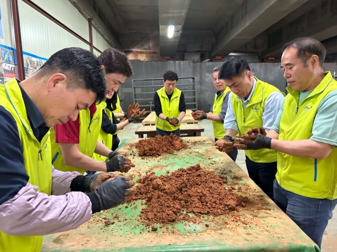 지난 4월, KGM 사내 봉사단 네바퀴동행을 비롯한 참가자들이 하천을 정화하기 위해 EM흙공을 제작하고 있다. 사진=KGM