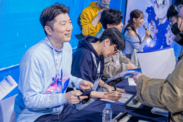 AGF 2025 부스에서 열린 개발진 사인회 현장의 모습. 왼쪽부터 김종호 네오위즈 사업부장, 겜프스엔의 이준희 브더2 총괄 PD와 '색종이' 한성 메인 원화 팀장. 사진=네오위즈