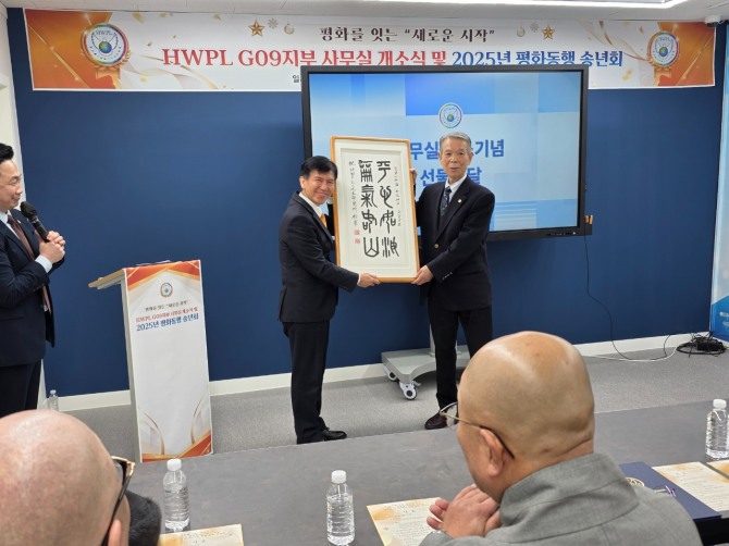 지난 26일 이석구 명예이사가 개소 기념 평화의 내용 액자를 전달 받고 있다=사진 김양훈 기자