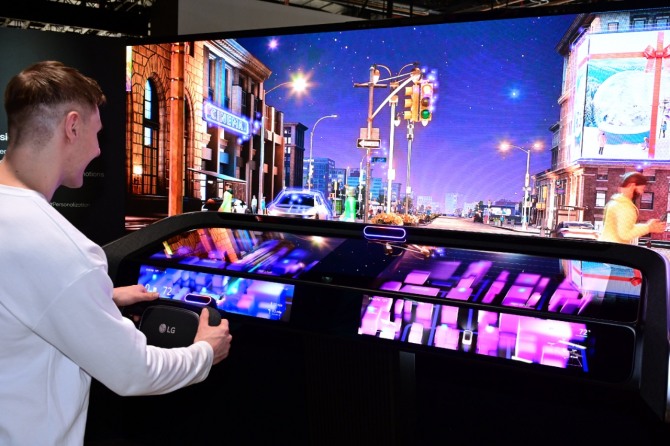 모델이 인캐빈 센싱 기술에 AI가 적용된 차량용 비전 솔루션을 체험하고 있다. AI가 운전자의 시선을 분석해 바라보고 있는 곳의 정보를 제공한다. 사진=LG전자