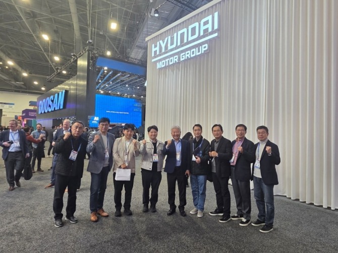 정명철 에티버스그룹 회장과 경영진이 CES 2026 현장에서 주요 기술 기업 부스를 잇달아 방문한 뒤 현대자동차그룹 전시 부스 앞에서 단체 사진을 촬영하고 있다.  사진=에티버스그룹