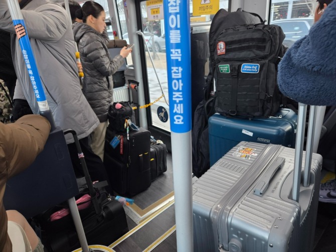 19일 오후 증차된 셔틀버스 내부가 캐리어를 든 입석 승객들로 혼잡한 모습이다. 사진=안우빈 기자